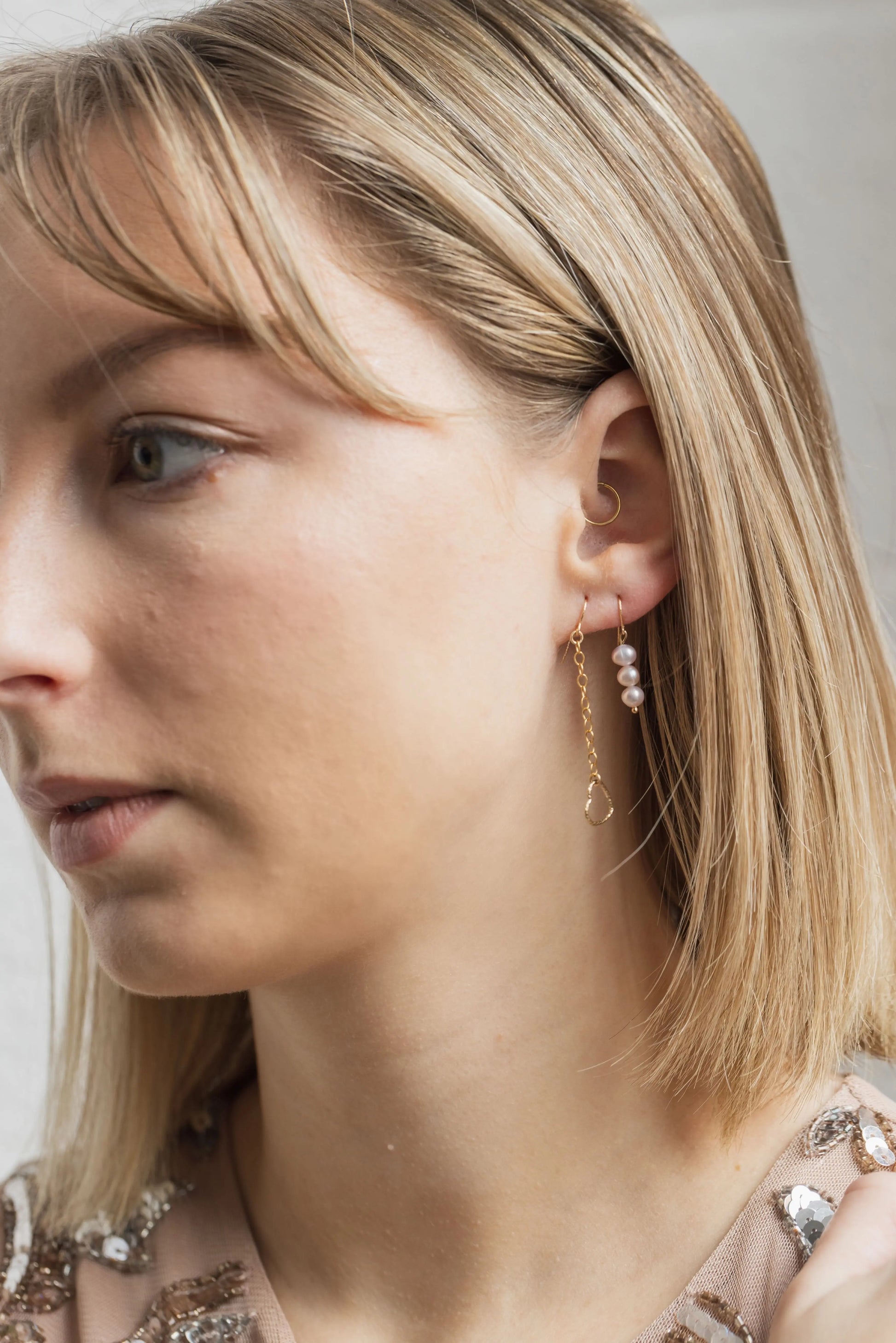 Boucles d'oreilles asymétriques en perles d'eau douce roses portées