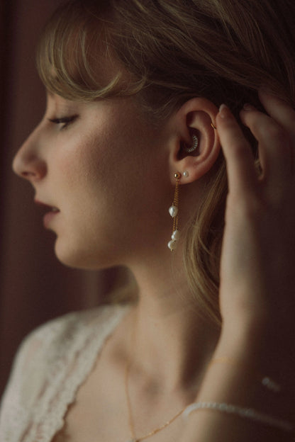 Boucles d'oreilles portées avec des perles d'eau douce baroques pour un mariage
